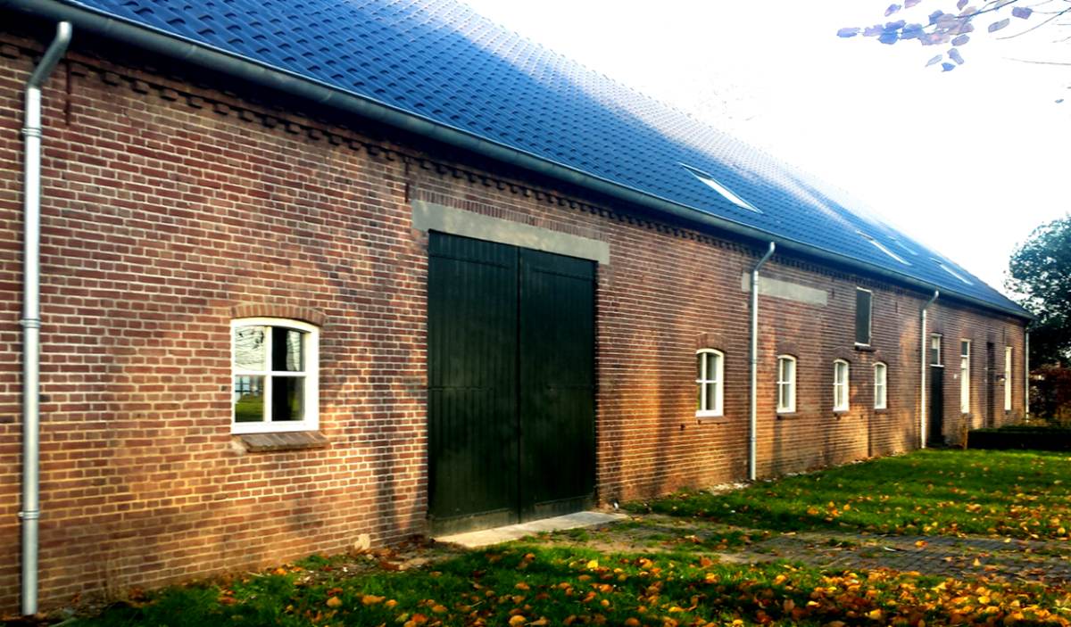 Zinken dakgoten en regenpijpen op een boerderij in Reek