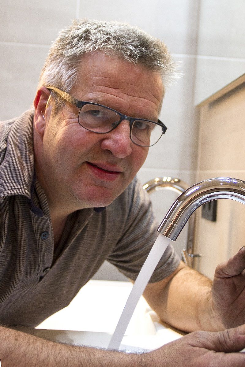 Loodgieter Peter Zegers bij een wastafelkraan